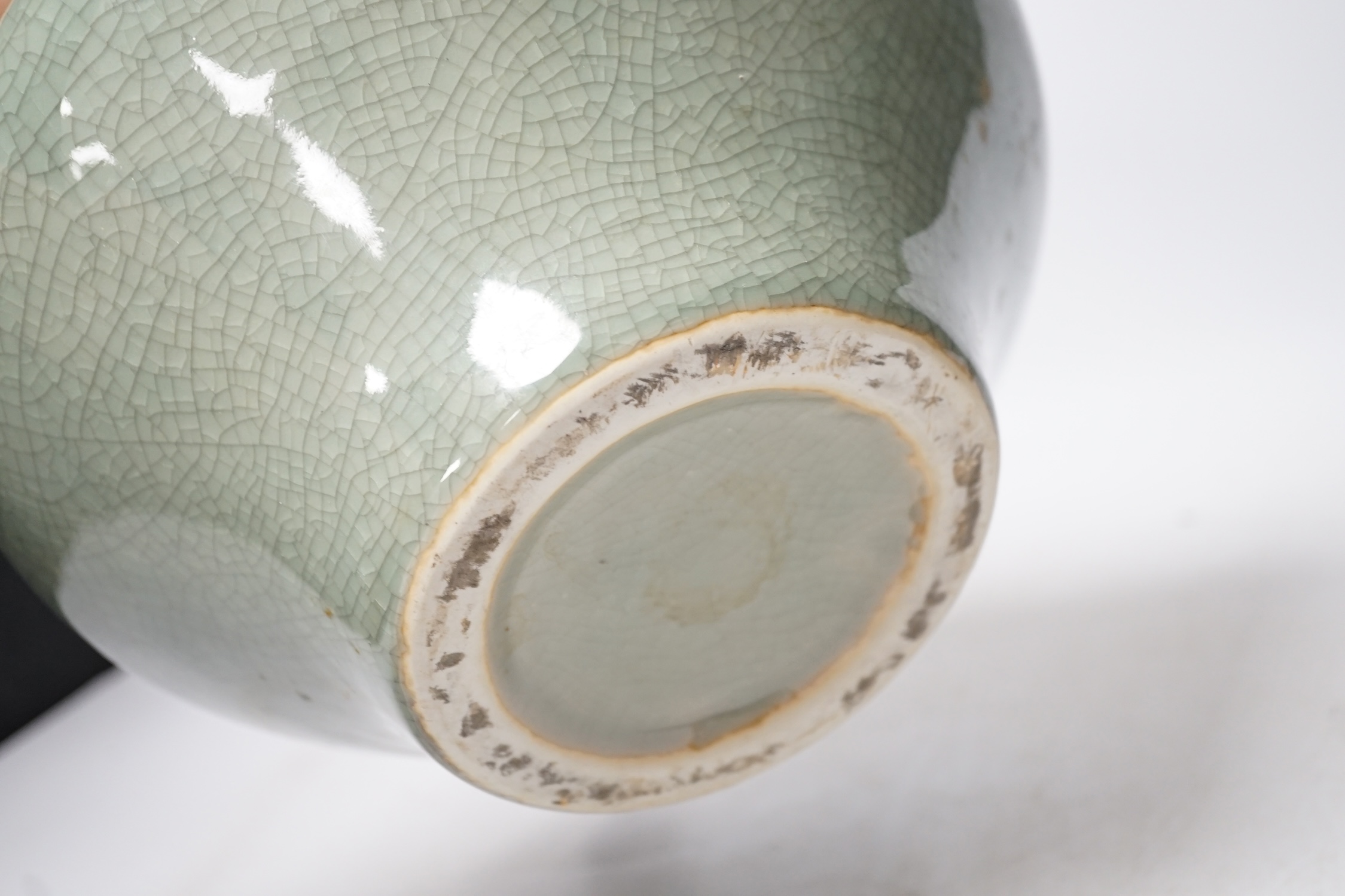 Three pieces of Asian pottery items comprising a Japanese blue and white dish, a green crackleware squat vase and an early 17th century Swatow jarlet, largest 18cm high. Condition - fair